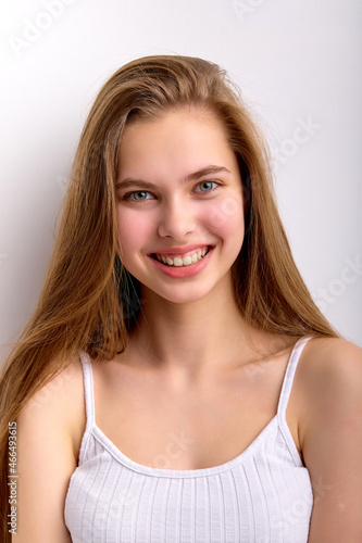 Close-up portrait of cheerful caucasian female with long natural hair looking at camera happily, teen girl with no make-up on face, natural and beautiful. isolated white studio background