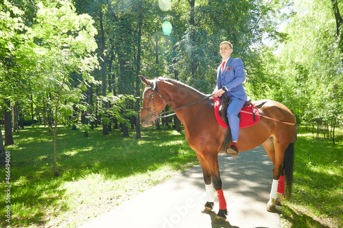 Photography A man riding on horseback in green summer sunny park