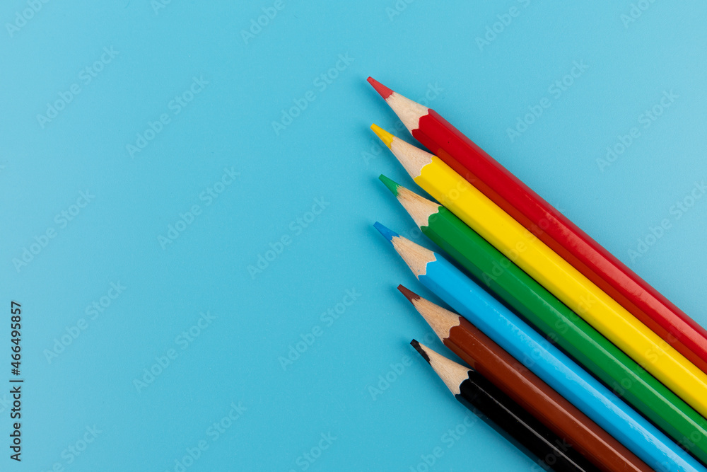 Six colored pencils close-up on a blue background with a copy of the space. The texture of bright colored wooden pencils. Six colored pencils close-up on a blue background with a copy of the space. The texture of bright colored wooden pencils.