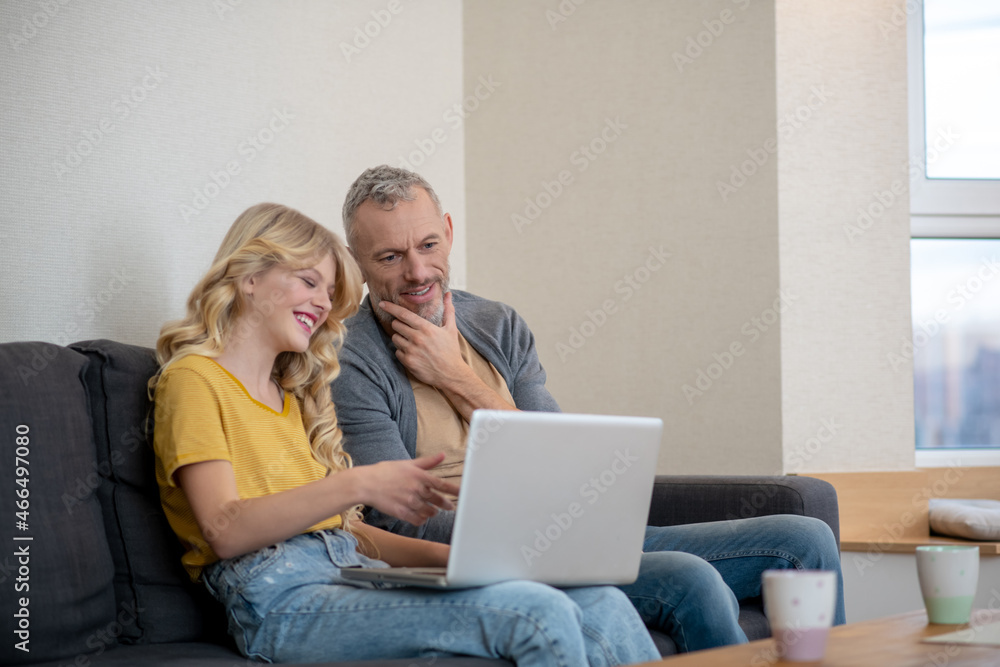 Father and daughter watching something on a laptop Father and daughter watching something on a laptop