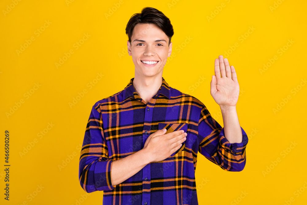 Photo of cute brunet millennial guy pray wear plaid shirt isolated on yellow color background Photo of cute brunet millennial guy pray wear plaid shirt isolated on yellow color background