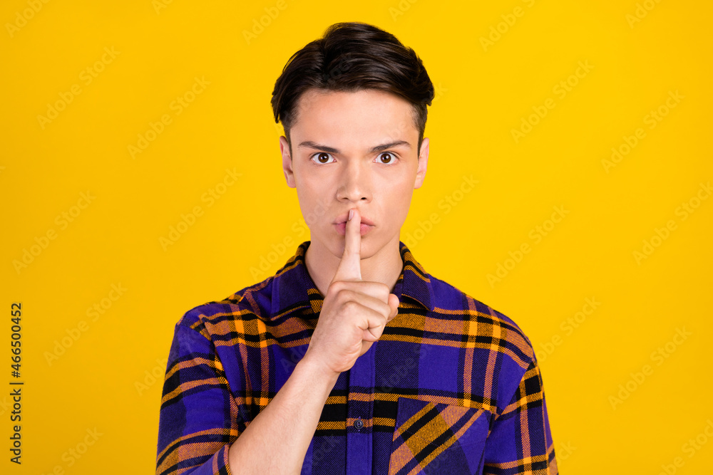 Photo of look brunet millennial guy finger lips wear plaid shirt isolated on yellow color background Photo of look brunet millennial guy finger lips wear plaid shirt isolated on yellow color background