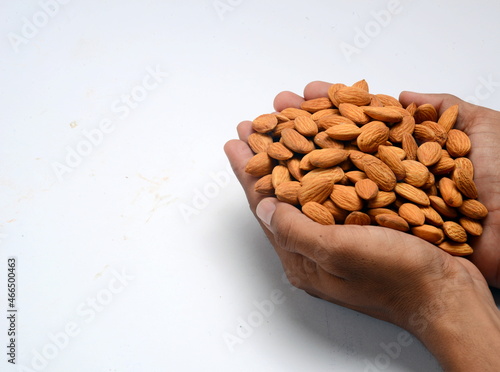 Fresh almonds in the wooden bowl, Organic almonds, almonds border white background, Almond nuts on a dark wooden background. Healthy snacks. Top view. Free space for text.
 photo