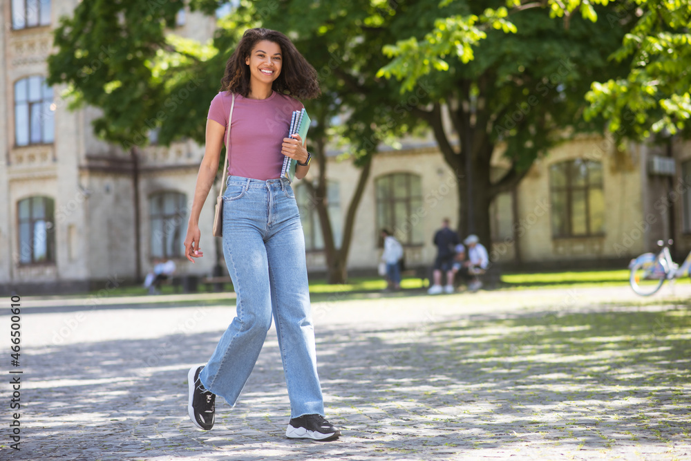 A cute girl in jeans walking in the park