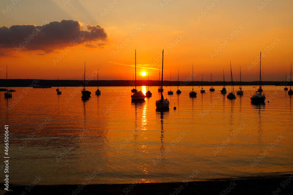 sunset at lake Ammersee in Herrsching with sailing boats resting on the water on a warm August night (Bavaria, Germany)	