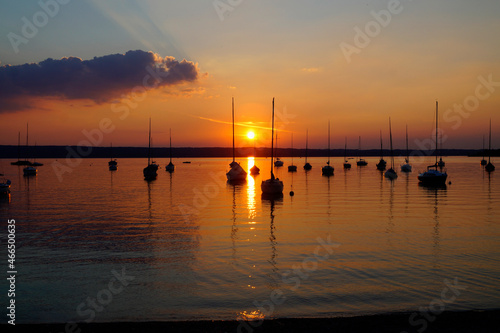 sunset at lake Ammersee in Herrsching with sailing boats resting on the water on a warm August night (Bavaria, Germany) © Julia