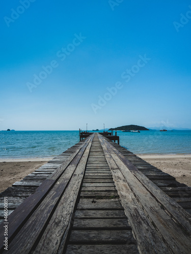 Scenic view of rustic wooden pier over peaceful beach against clear blue sky in summer. Koh Mak Island  Trat  Thailand.