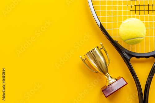 Tennis champion award - small golden trophy cup with tennis racket and ball
