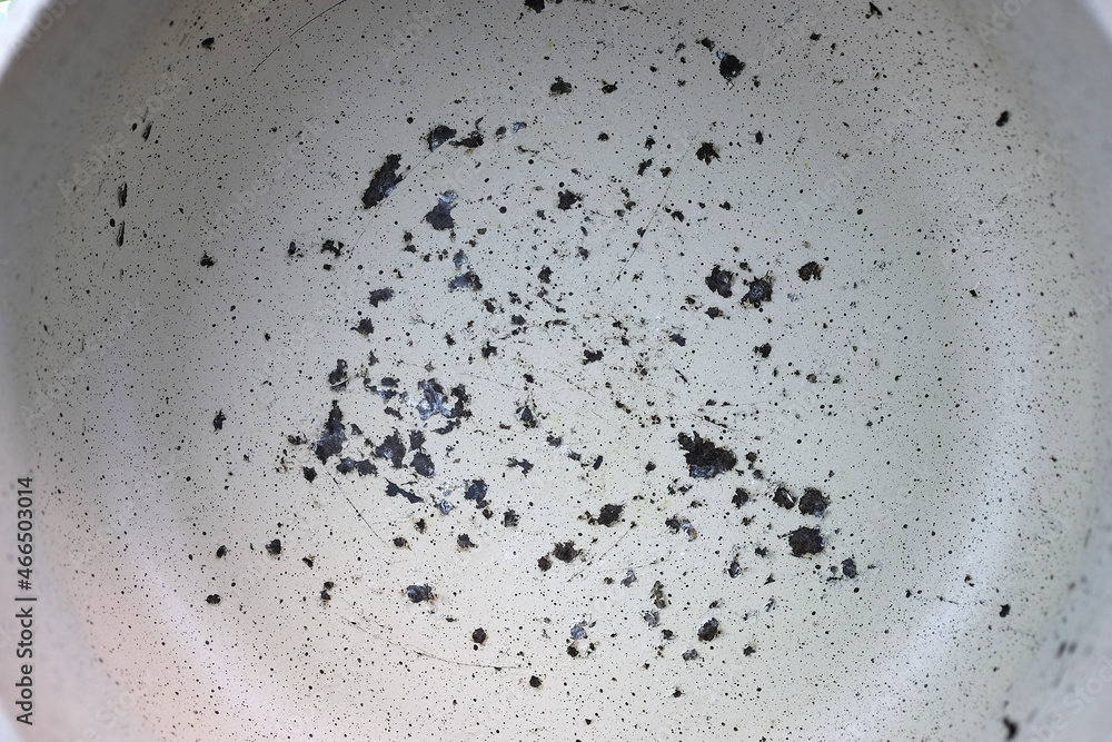 Obraz premium Scratched nonstick pan surface in close-up. Frying pan with an old, shabby, cracked ceramic coating danger. Erased surface on the pot. A ruined, non stick skillet on the kitchen counter