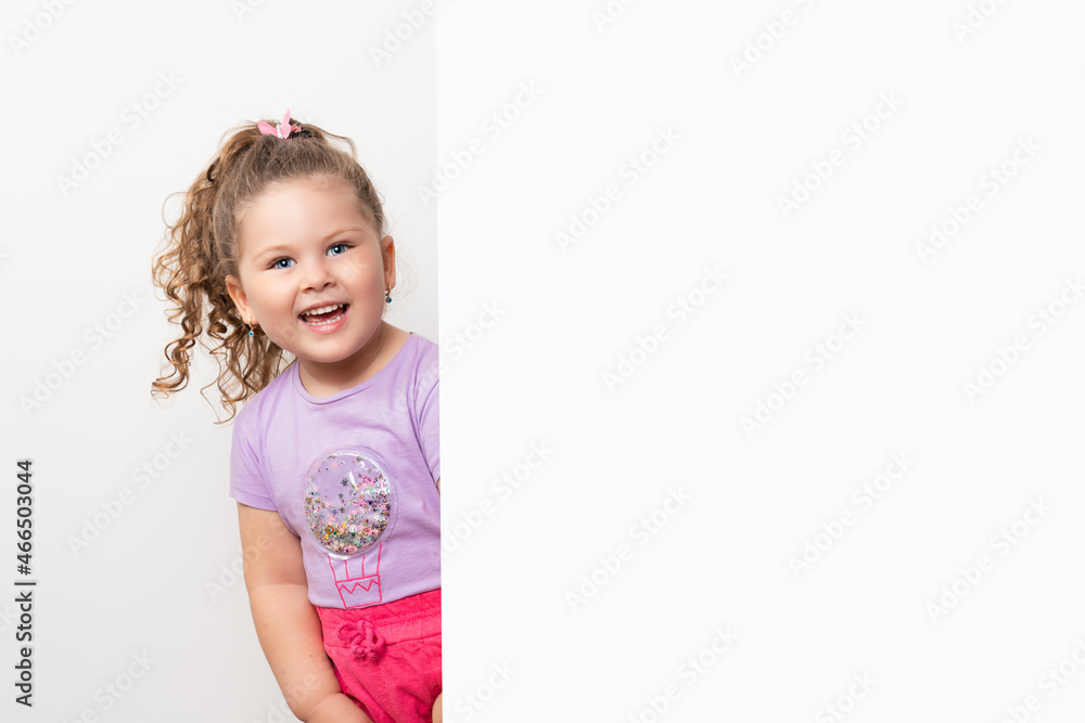 Smiling blue eyed and cute little baby girl peeking behind a white wall. Smiling blue eyed and cute little baby girl peeking behind a white wall.