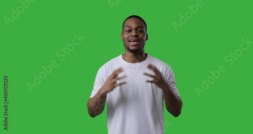 African american man explaining and giving thumbs up gesture over green background
