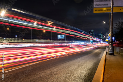 night landscape with a freeway and fast moving cars leaving a solid trail 
