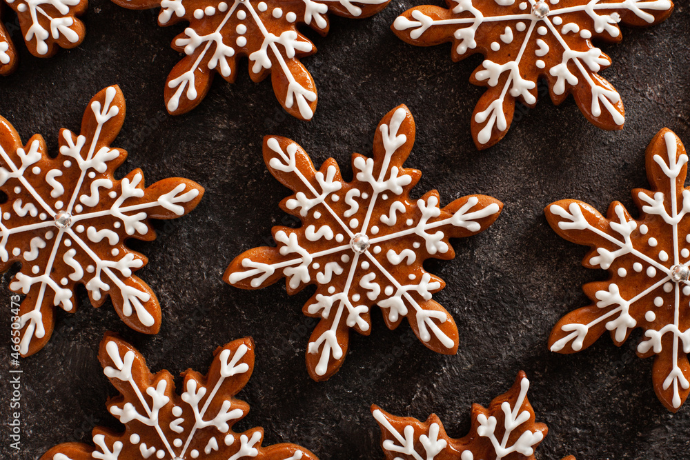 Christmas background with homemade snowflake shape gingerbread cookies on concrete table. New Year celebration traditions concept. Christmas background with homemade snowflake shape gingerbread cookies on concrete table. New Year celebration traditions concept.