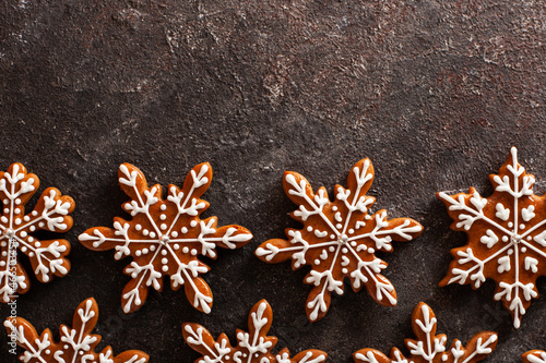 Christmas background with homemade snowflake shape gingerbread cookies on concrete table with copyspace. New Year celebration traditions concept.