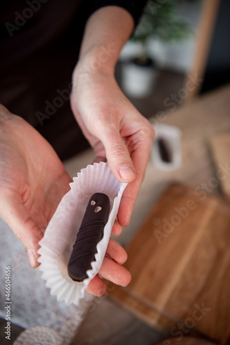 Chocolate with caramel and nuts. Copy space. Close-up. Soft focus background. Hands 