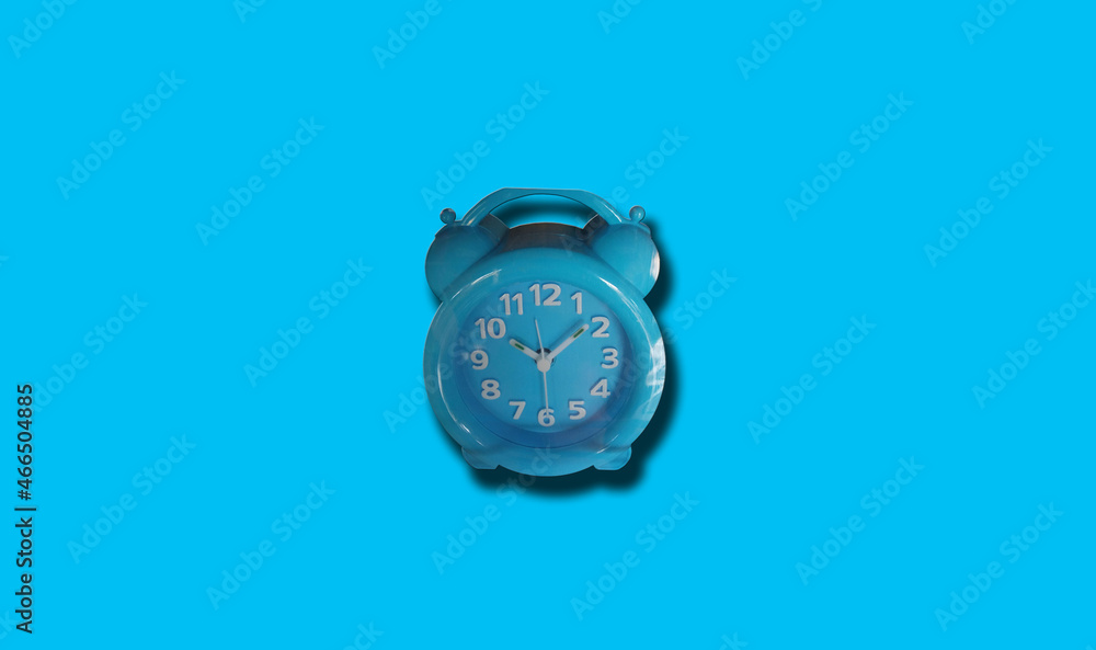Single analog alarm clock isolated on light cyan for background or stock photo, clock telling time, object, product Single analog alarm clock isolated on light cyan for background or stock photo, clock telling time, object, product