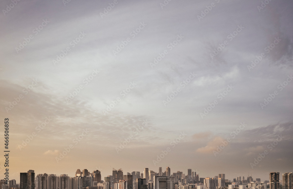 Fototapeta premium Wispy clouds above Singapore city skyline at sunrise