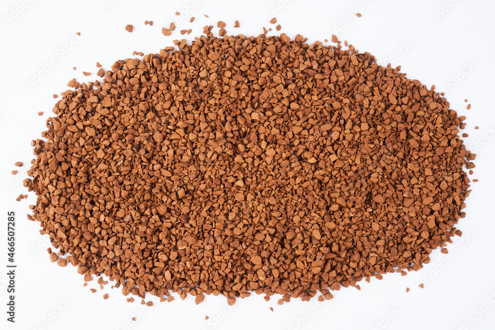Freeze-dried instant coffee on white background close-up. Heap of powdered brown coffee product scattered on the table Freeze-dried instant coffee on white background close-up. Heap of powdered brown coffee product scattered on the table
