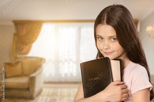 Happy kid girl read bible study. Worship at home.
