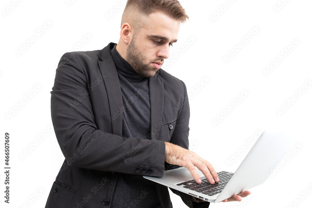 A guy in business clothes is working on a laptop on a white background A guy in business clothes is working on a laptop on a white background