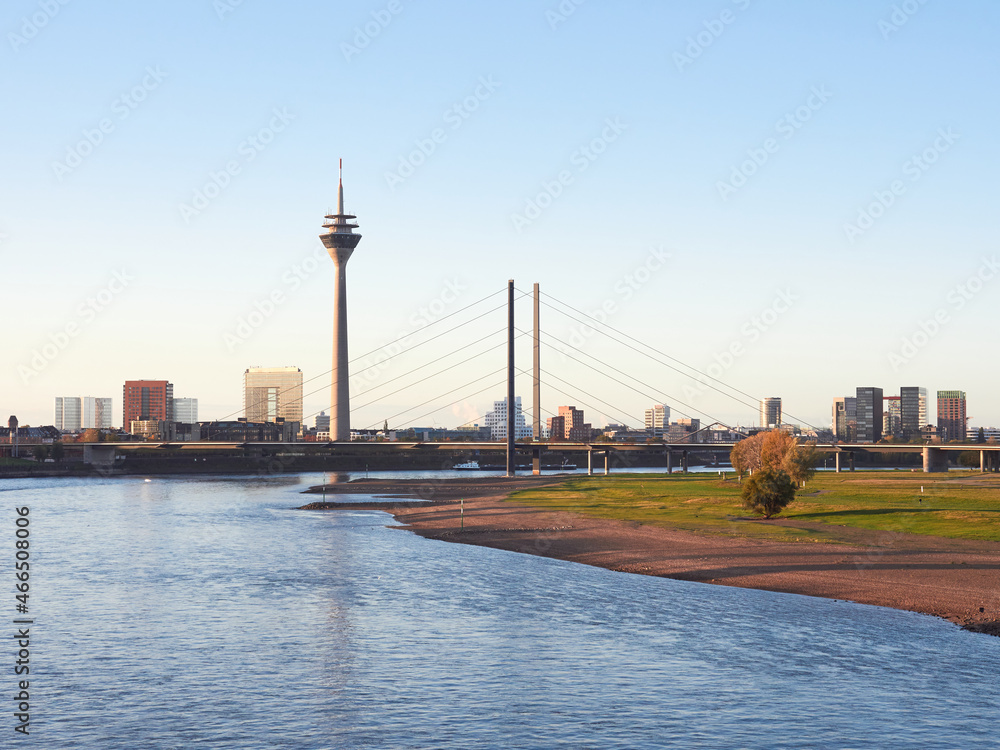 Panorama view of the city of Dusseldorf from the Rhine in Germany. City skyline with the famous tower and bridge at sunrise.