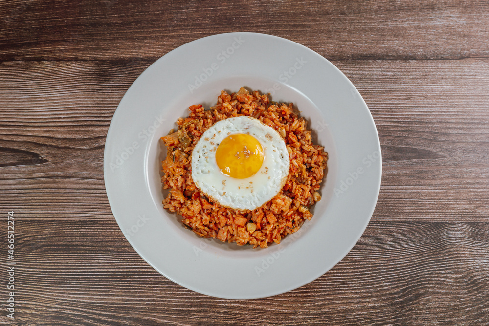 Korean food kimchi fried rice dish with fried egg on white plate Korean food kimchi fried rice dish with fried egg on white plate