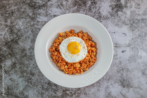 Korean food kimchi fried rice dish with fried egg on white plate