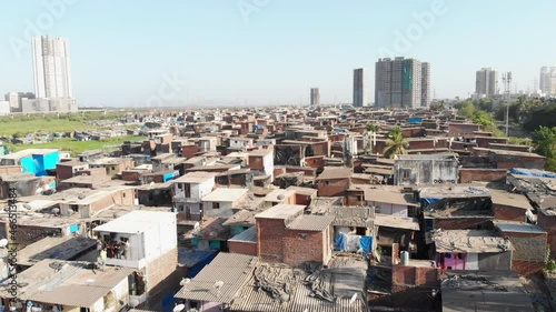 An aerial drone movement shot of the closely packed urban slums or shanty town housing situated in suburban part of the Mumbai city
