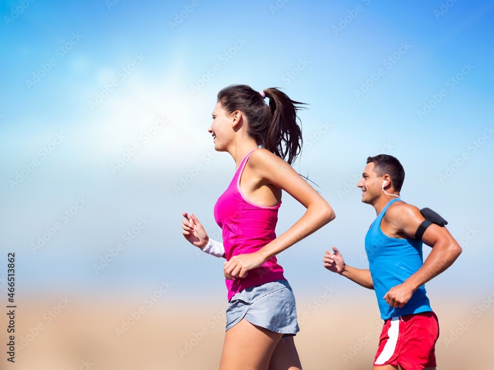 Happy young man and woman in sportswear running together Happy young man and woman in sportswear running together