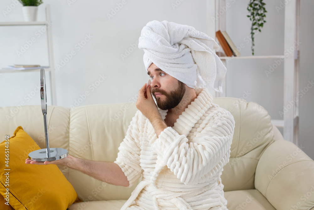 Handsome man cleaning face skin with cotton pads. Spa, body and skin care for male concept. Handsome man cleaning face skin with cotton pads. Spa, body and skin care for male concept.
