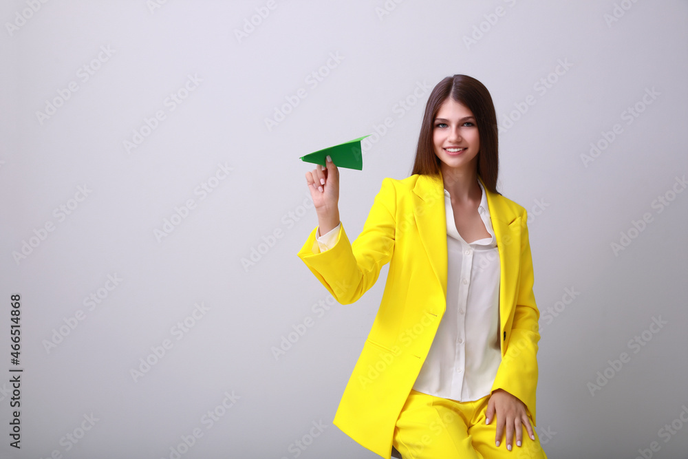 Beautiful teenage girl with paper plane on grey background. Space for text Beautiful teenage girl with paper plane on grey background. Space for text