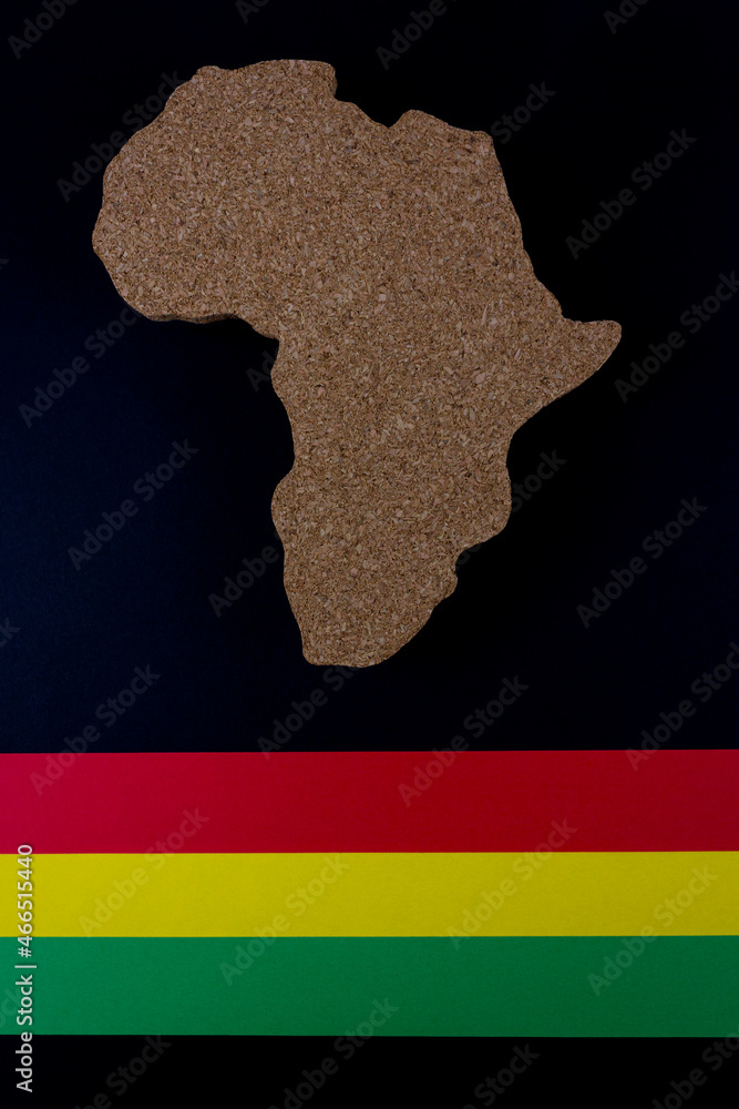 Obraz premium Black History Month concept. Africa Continent shape with traditional red, yellow and green color bar. Space for your text. Flat lay.