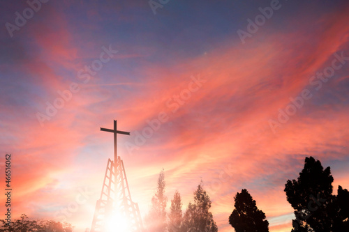cross religion symbol silhouette in Iron tower over sunset sky background