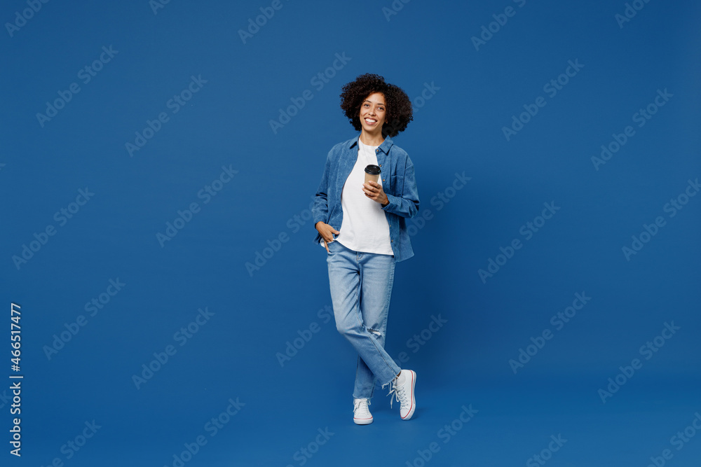 Full body young fun smiling happy black woman in casual clothes shirt white t-shirt hold takeaway delivery craft paper brown cup coffee to go isolated on plain dark blue background studio portrait Full body young fun smiling happy black woman in casual clothes shirt white t-shirt hold takeaway delivery craft paper brown cup coffee to go isolated on plain dark blue background studio portrait