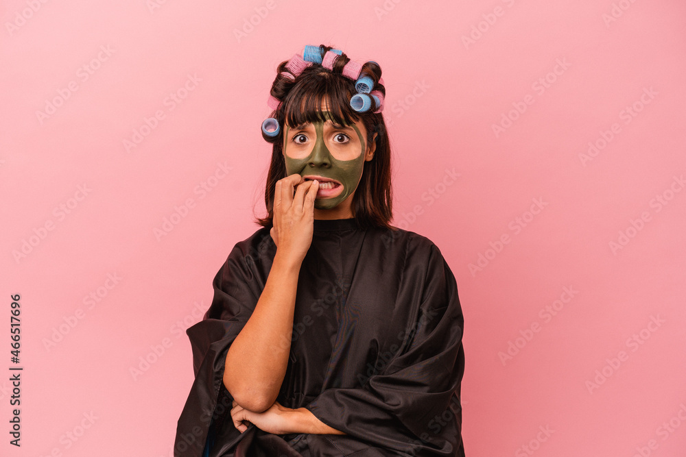 Young mixed race woman waiting in a Beaty salon isolated on pink background biting fingernails, nervous and very anxious. Young mixed race woman waiting in a Beaty salon isolated on pink background biting fingernails, nervous and very anxious.