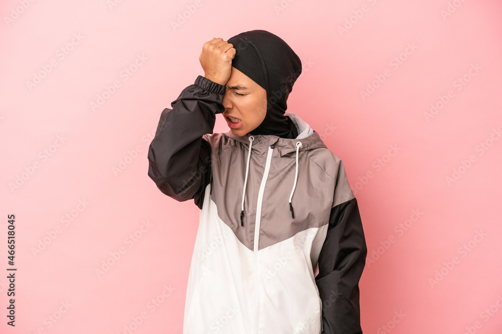 Young Arab woman with sport burqa isolated on pink background forgetting something, slapping forehead with palm and closing eyes. Young Arab woman with sport burqa isolated on pink background forgetting something, slapping forehead with palm and closing eyes.