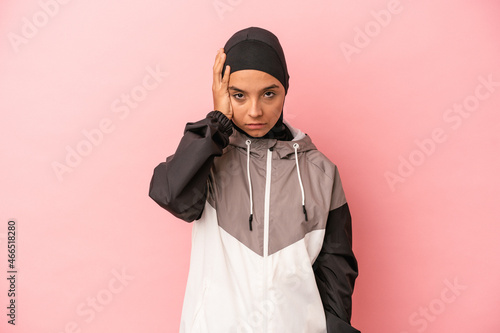 Young Arab woman with sport burqa isolated on pink background tired and very sleepy keeping hand on head.