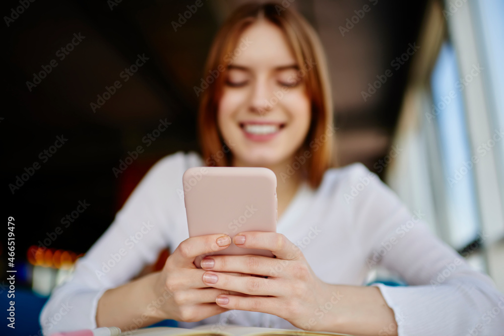 Blurred female blogger messaging in social networks using cellphone technology indoors, selective focus on millennial hands browsing content publication during leisure for chatting via smartphone Blurred female blogger messaging in social networks using cellphone technology indoors, selective focus on millennial hands browsing content publication during leisure for chatting via smartphone
