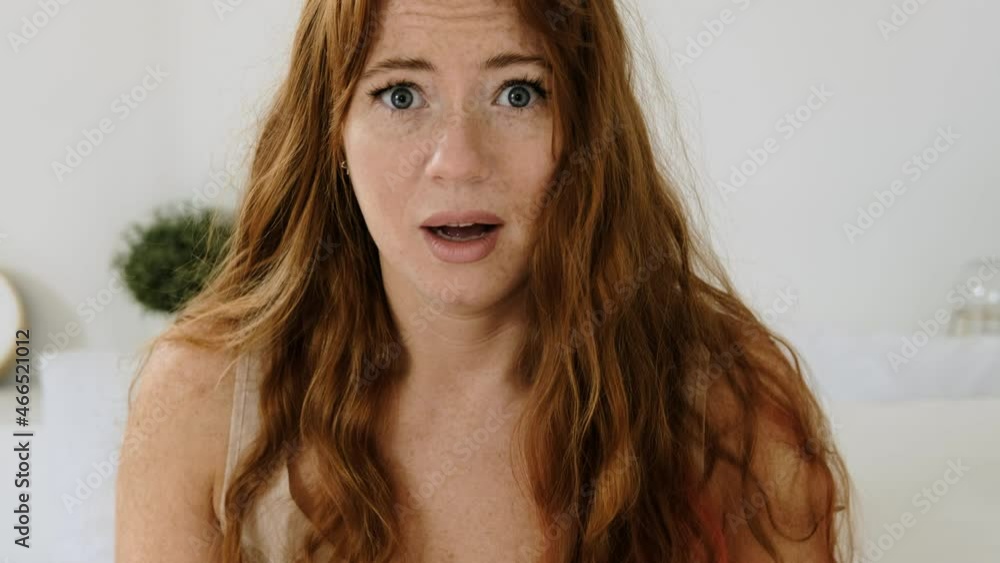 Vidéo Stock Young woman wakes up abruptly and looks at the alarm clock in her smartphone. girl