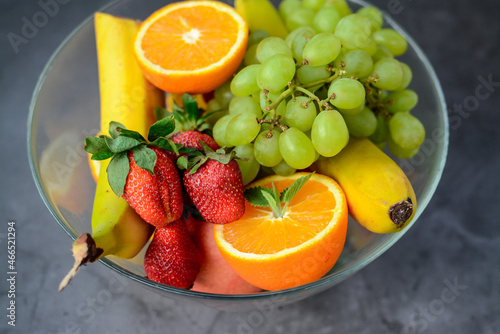 Various fruits and berries on dark stone table