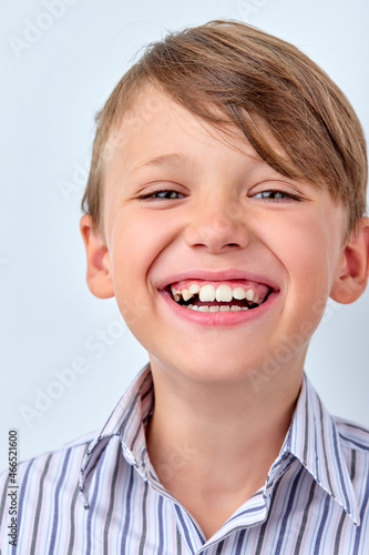 Attractive caucasian child boy with perfect toothy smile and clean skin cute face smiling laughing posing at camera isolated in studio on white background. human emotions, childhood concept.