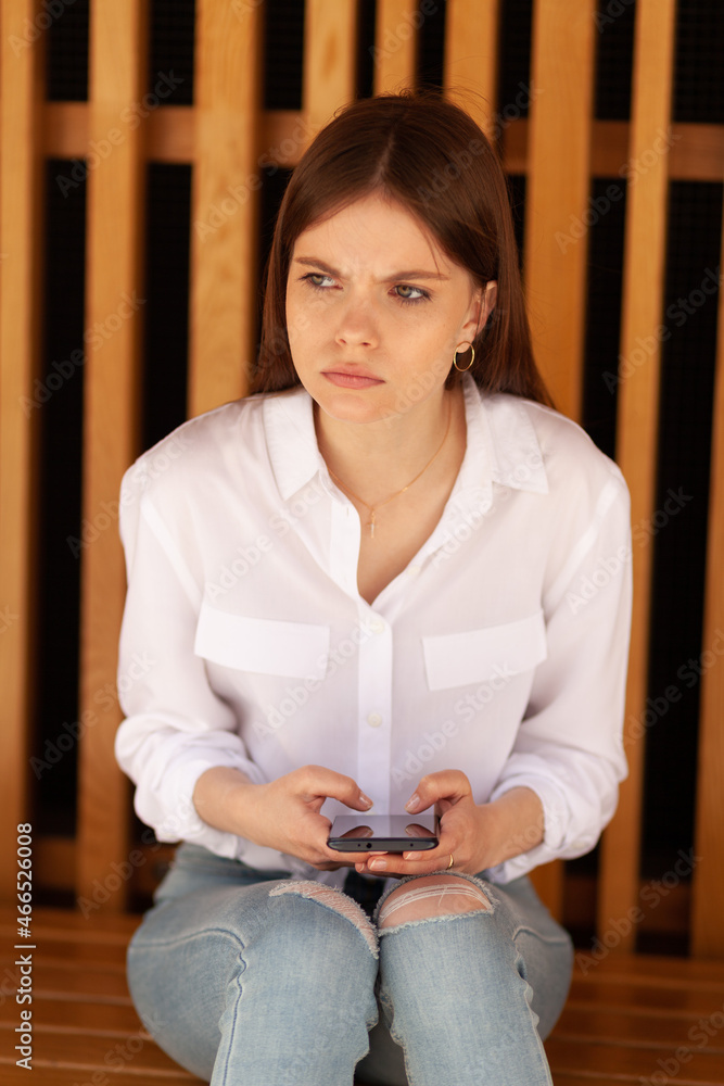 Modern cyberbullying on social media. Frustrated and scared teenager with smartphone. Modern cyberbullying on social media. Frustrated and scared teenager with smartphone.