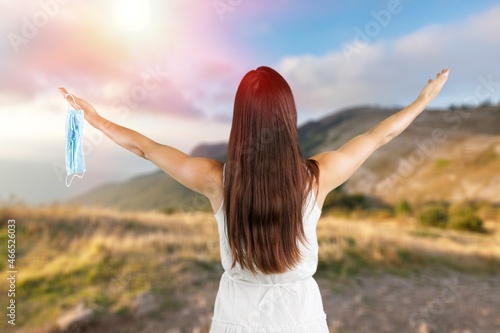 Woman with raising hands on the nature background