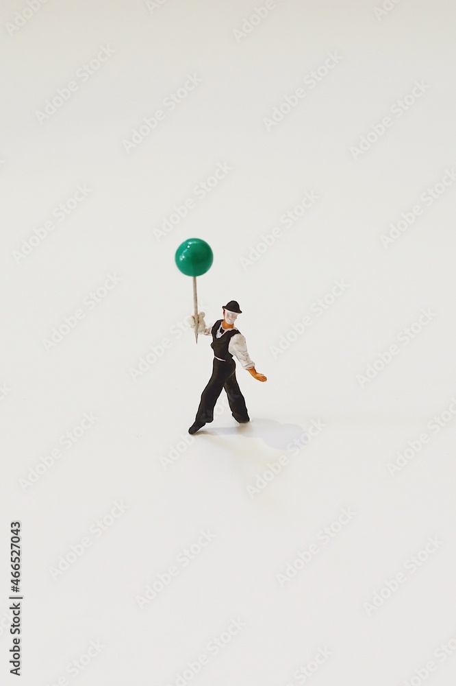 Miniature people clown giving balloons to children. Miniature people clown giving balloons to children.