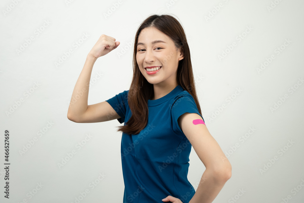 Happy Asian woman showing strong arm and bandage after they get a vaccine. Happy Asian woman showing strong arm and bandage after they get a vaccine.