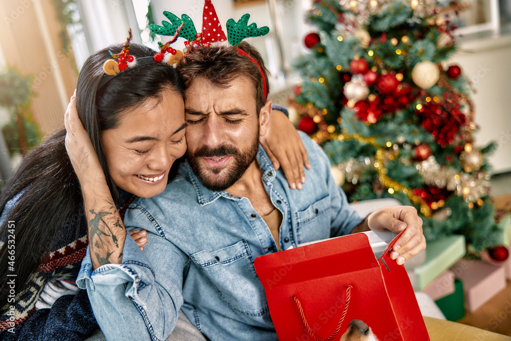 a cheerful couple sharing love and surprises on Christmas a cheerful couple sharing love and surprises on Christmas