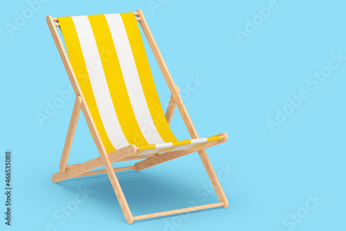 Tablou canvas Yellow striped beach chair for summer getaways isolated on blue background
