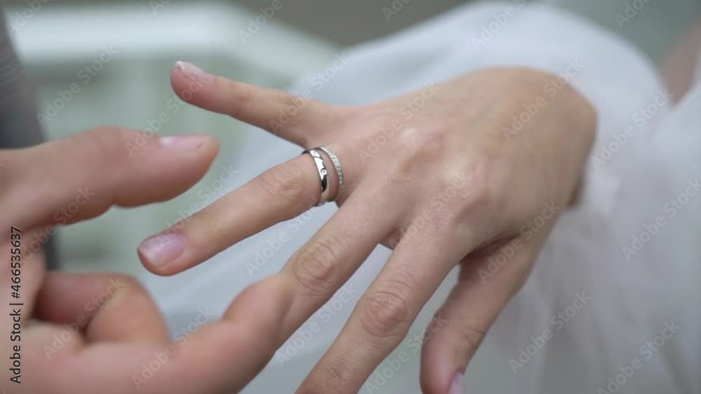 Bride and groom exchange wedding rings at ceremony close up. Put on finger jewelry symbol of love and togetherness. Man and woman in love. Marriage outdoors in summer.