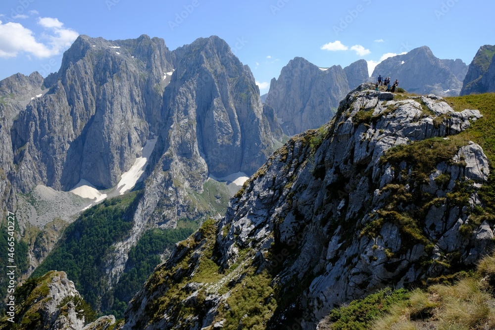 Mountain views during trekking along beautiful tourist loop on Montenegrin side of  Prokletije Mountains: Volusnica (1879 m) - Taljanka (2018 m) - Popadija (2057 m). Silhouettes of people on ridge.