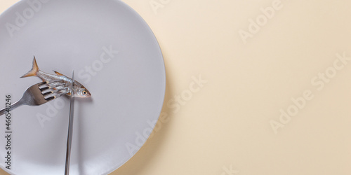 Obraz na plátne A knife and fork cut live raw fish on a plate